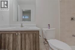 Bathroom with vanity, a tile shower, and toilet - 