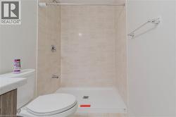 Bathroom featuring a tile shower and toilet - 
