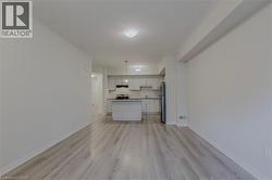 Kitchen featuring open floor plan, light wood-style flooring, freestanding refrigerator, and baseboards - 
