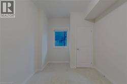 Unfurnished room with light colored carpet and baseboards - 