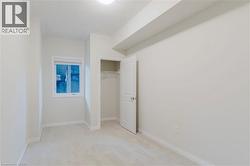 Unfurnished bedroom featuring a closet, light colored carpet, baseboards, and a textured ceiling - 