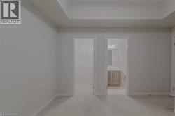 Empty room with light carpet, baseboards, and a sink - 