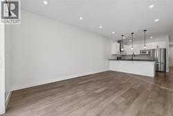 Unfurnished living room featuring recessed lighting and dark wood finished floors - 