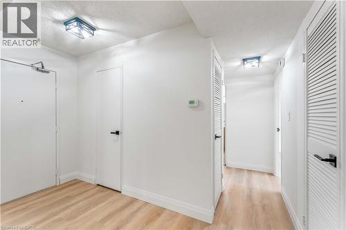 Hall featuring a textured ceiling and light wood-style floors - 120 Duke Street Unit# 905, Hamilton, ON - Indoor Photo Showing Other Room