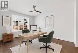 Office area featuring dark wood-type flooring and a ceiling fan - 