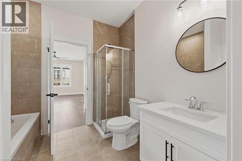 Full bath featuring a garden tub, a stall shower, vanity, and light tile patterned floors - 4 Elgin Street W, Norwich, ON - Indoor Photo Showing Bathroom