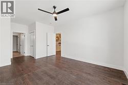 Unfurnished bedroom with dark wood finished floors, ceiling fan, and a closet - 