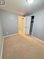 Unfurnished bedroom featuring a closet, a textured ceiling, and carpet flooring - 