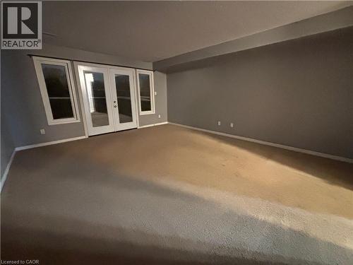 Carpeted empty room with french doors and baseboards - 50 Howe Drive Unit# 12A, Kitchener, ON - Indoor Photo Showing Other Room
