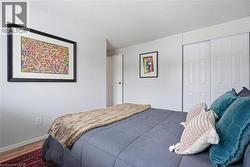 Bedroom with a textured ceiling, wood finished floors, and a closet - 