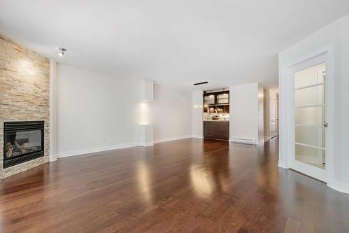 Living room - 201-691 Mtée Des Pionniers, Terrebonne (Lachenaie), QC - Indoor Photo Showing Living Room With Fireplace