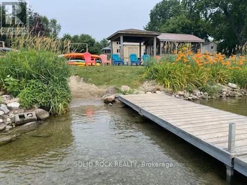 Rock retaining wall & small beach, lillies galore - 5 Shoreline Road, Edwardsburgh/Cardinal, ON - Outdoor With Body Of Water