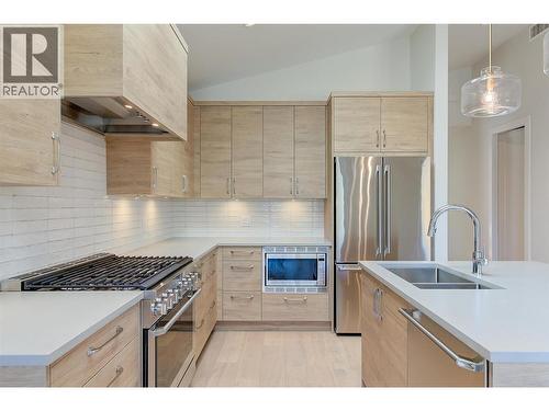 sleek flat-panel cabinetry, quartz countertops, high-end appliances - 761 Barnaby Road, Kelowna, BC - Indoor Photo Showing Kitchen With Double Sink With Upgraded Kitchen