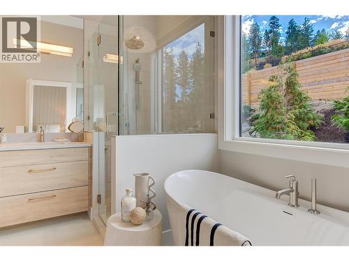 Spa-inspired ensuite featuring dual vanities, a soaker tub, a glass-and-tile shower - Staged photos are of 759 Barnaby Rd - 761 Barnaby Road, Kelowna, BC - Indoor Photo Showing Bathroom