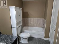 Bathroom with vanity, toilet, a bathtub, and hardwood / wood-style floors - 