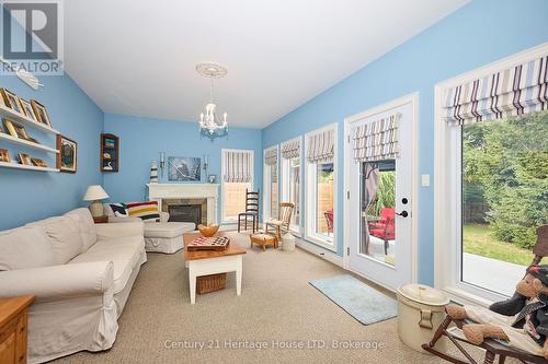 Sunroom with doors to backyard and fireplace - 32 Sunrise Court, Fort Erie (Ridgeway), ON - Indoor Photo Showing Living Room With Fireplace