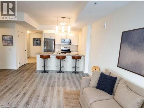 Kitchen with open floor plan, a breakfast bar, stainless steel appliances, hanging light fixtures, and a peninsula - 108 Garment Street Unit# 606, Kitchener, ON - Indoor