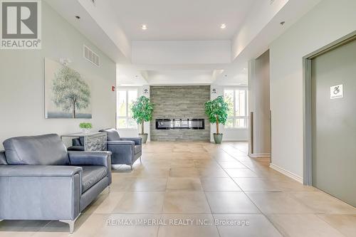 lobby - 309 - 1360 Costigan Road, Milton, ON - Indoor Photo Showing Living Room With Fireplace
