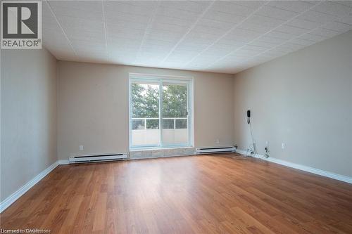 Unfurnished room with light wood-style flooring and a baseboard heating unit - 71 Vanier Drive Unit# 211, Kitchener, ON - Indoor Photo Showing Other Room