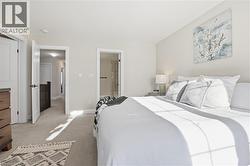 Carpeted bedroom featuring ensuite bathroom and baseboards - 