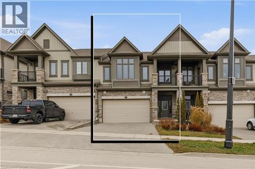 Craftsman-style house with a balcony, concrete driveway, brick siding, and a garage - 592 Mayapple Street, Waterloo, ON - Outdoor With Facade