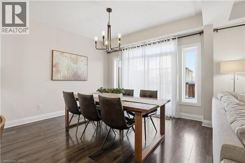 Dining area with dark wood-style flooring and a chandelier - 592 Mayapple Street, Waterloo, ON - Indoor Photo Showing Dining Room