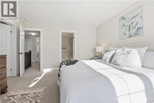 Carpeted bedroom featuring ensuite bathroom and baseboards - 592 Mayapple Street, Waterloo, ON - Indoor Photo Showing Bedroom