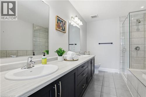 Full bath with light tile patterned floors, double vanity, and a stall shower - 592 Mayapple Street, Waterloo, ON - Indoor Photo Showing Bathroom