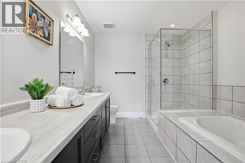 Full bathroom featuring double vanity, a shower stall, light tile patterned floors, a bath, and recessed lighting - 592 Mayapple Street, Waterloo, ON - Indoor Photo Showing Bathroom