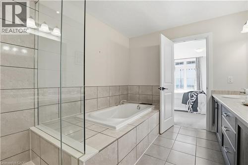 Bathroom with connected bathroom, vanity, light tile patterned flooring, and a garden tub - 592 Mayapple Street, Waterloo, ON - Indoor Photo Showing Bathroom