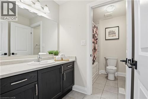 Bathroom featuring vanity, light tile patterned flooring, shower / bath combination with curtain, and a textured ceiling - 592 Mayapple Street, Waterloo, ON - Indoor Photo Showing Bathroom