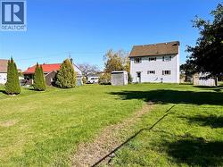 View of grassy yard with a storage unit - 