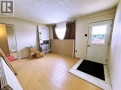 Entryway with a textured ceiling and hardwood / wood-style flooring - 