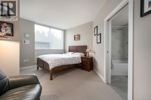 Carpeted bedroom featuring baseboards and connected bathroom - 305 3529 Dolphin Dr, Nanoose Bay, BC - Indoor Photo Showing Bedroom