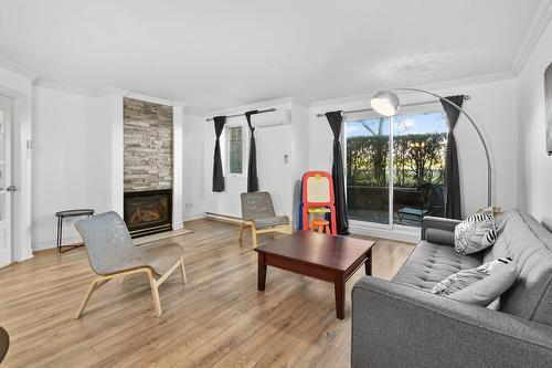 Salon - 101-6535 Boul. Chevrier, Brossard, QC - Indoor Photo Showing Living Room With Fireplace