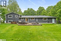 Back of house with a hot tub, a yard, and a patio - 