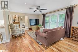 Living room with light wood-style flooring, recessed lighting, and ceiling fan - 