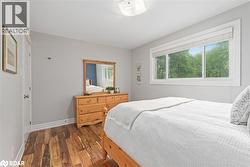 Bedroom with dark wood-type flooring and baseboards - 