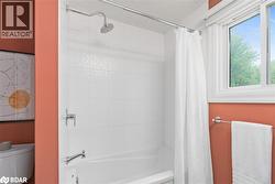 Bathroom featuring shower / bath combination with curtain and toilet - 