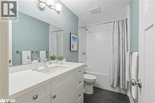 Full bathroom featuring vanity, shower / bath combo, and dark tile patterned floors - 13609 Sixth Line, Limehouse, ON - Indoor Photo Showing Bathroom