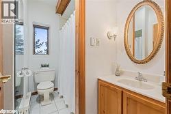 Bathroom with light tile patterned floors, vanity, and a shower with shower curtain - 