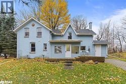 View of front of property featuring a chimney, a front yard, and stucco siding - 