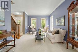 Living room with healthy amount of natural light, carpet, stairway, and crown molding - 