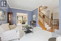 Carpeted living room with stairway and ornamental molding - 