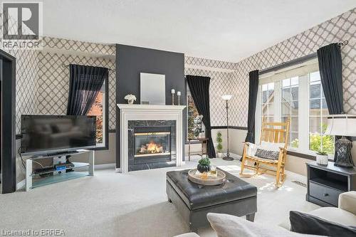 Living area featuring wallpapered walls, carpet flooring, and a fireplace - 119 Parkview Lane, Rockwood, ON - Indoor Photo Showing Living Room With Fireplace