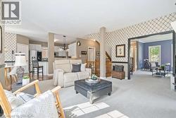 Living area featuring wallpapered walls, an accent wall, and carpet - 