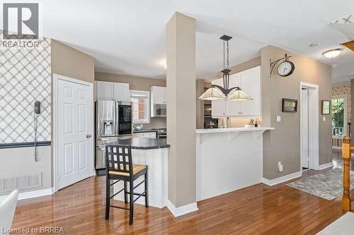 Kitchen with a breakfast bar, white cabinets, decorative light fixtures, and stainless steel appliances - 119 Parkview Lane, Rockwood, ON - Indoor Photo Showing Kitchen