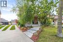 View of property hidden behind natural elements featuring a front lawn, covered porch, a garage, and an outbuilding - 119 Parkview Lane, Rockwood, ON  - Outdoor With Facade 