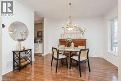 Dining area featuring a chandelier and wood finished floors - 