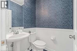 Bathroom featuring wainscoting and wallpapered walls - 